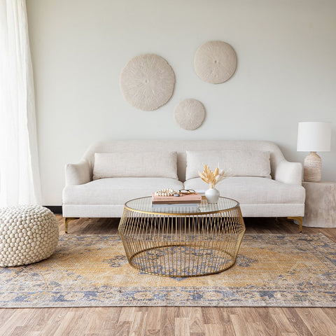 Cream Ember sofa against a white wall with a gold coffee table